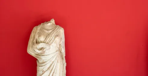 Statue with head missing, against red background - from unsplash.