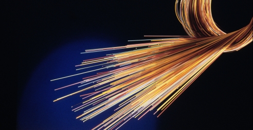 A section of fibre optic cable is foreground against a dark background