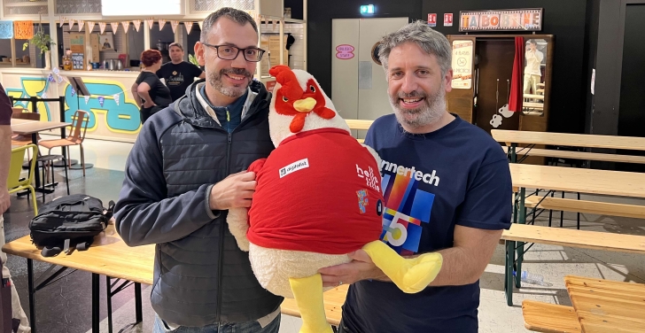 Adrien Sirjacques and Tony Barker pose proudly with DrupalCon Lille mascot Lil’ Rooster.