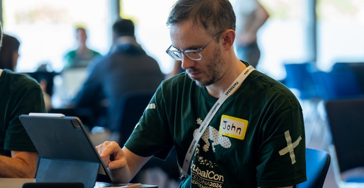 John Cook in his green mentor T-shirt in the contribution room at DrupalCon Barcelona 2024. Picture by Bram Driesen