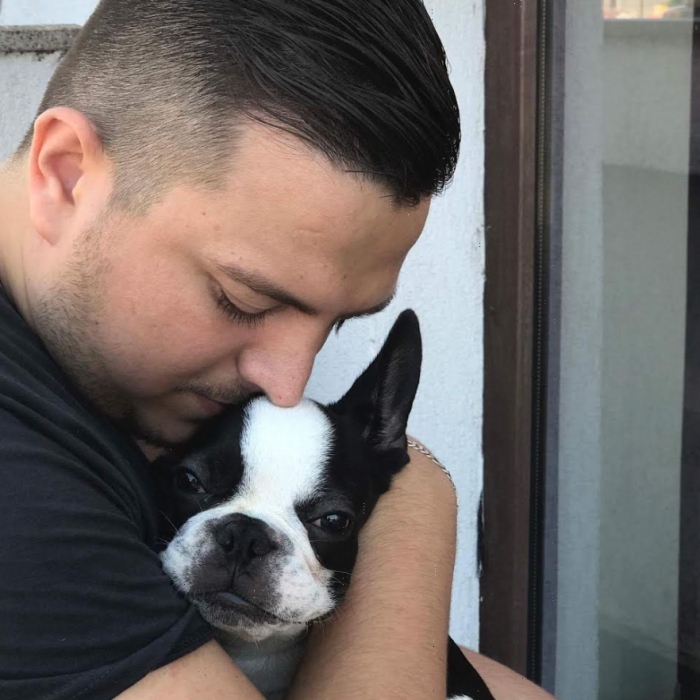 Valentine hugs his French bulldog Tito